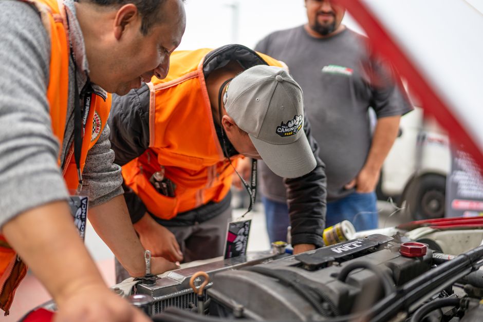 Smiling auto mechanic team ready to assist with tire replacement